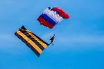 На нее эффектно приземляются парашютисты с праздничными флагами